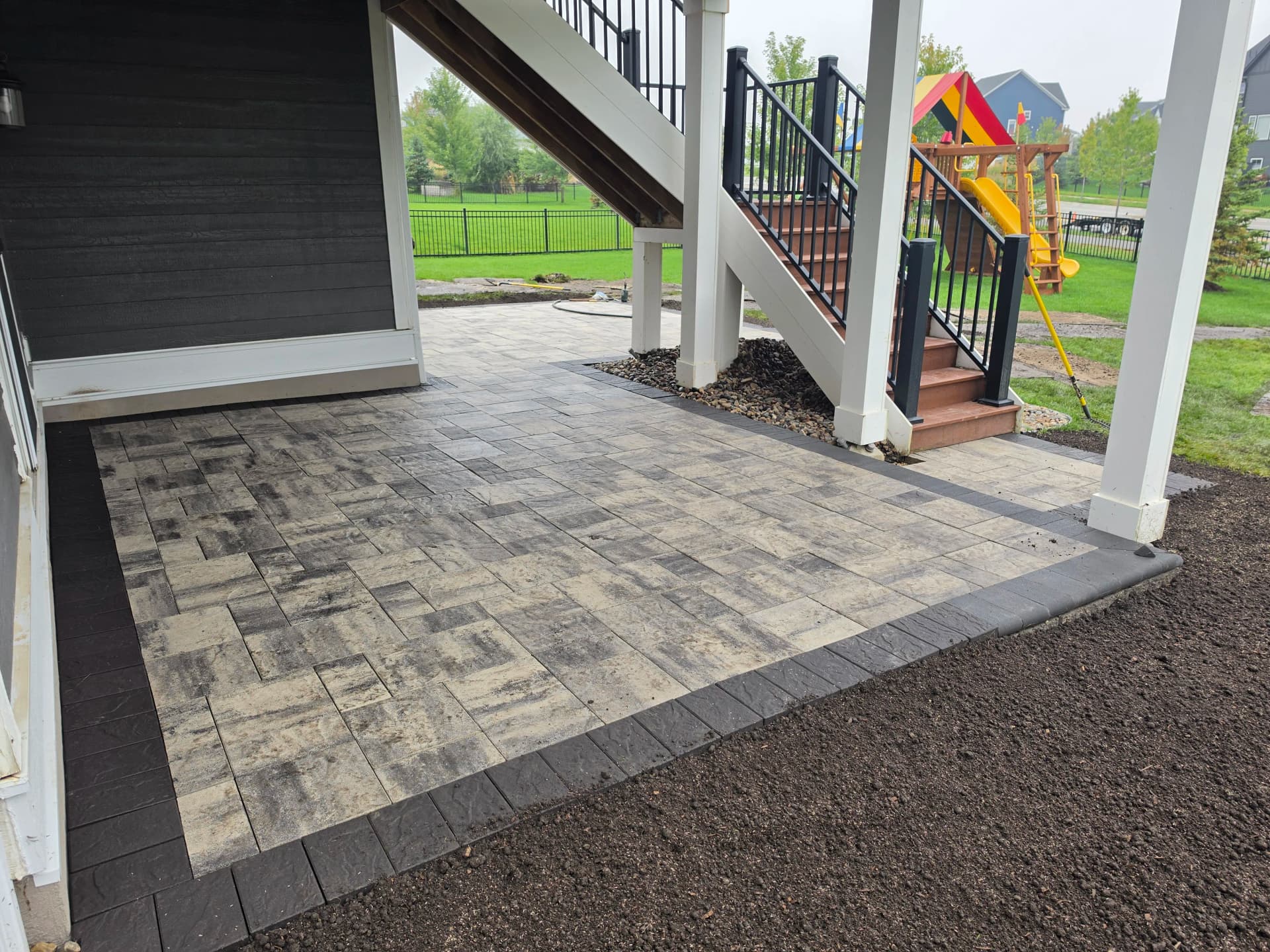 Paver Patio Installation Around Existing Deck Stairs image