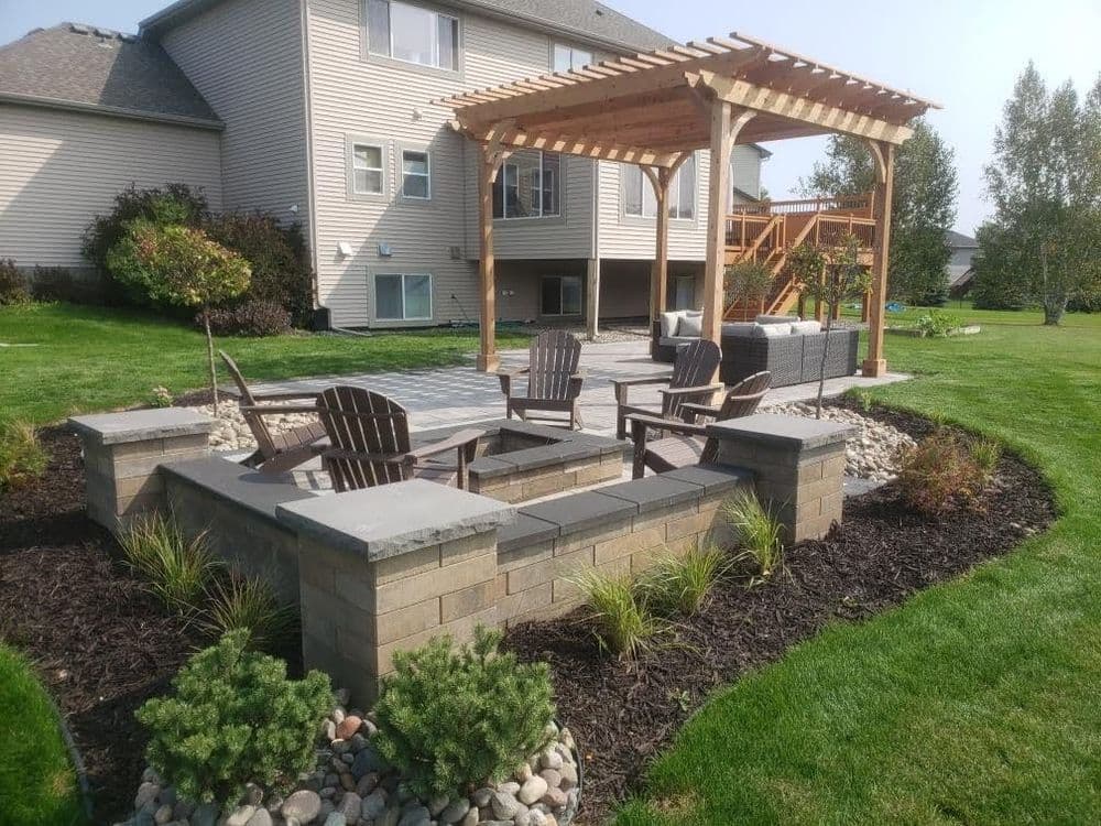 Cozy outdoor patio with seating, pergola, and landscaped garden in residential backyard.